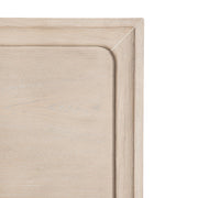 Front facing close up of the headboard corner on a transitional light oak eastern king platform bed with two storage drawers, on a white background