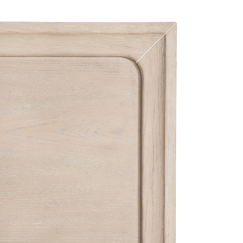 Front facing close up of the headboard corner on a transitional light oak eastern king platform bed with two storage drawers, on a white background