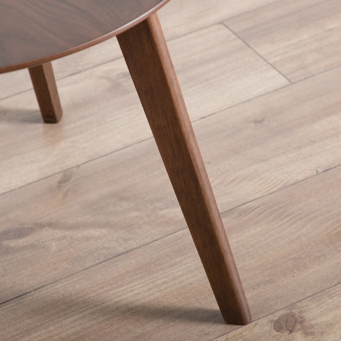 Close up view of the leg of a mid-century modern walnut finish round wood side table with splayed legs