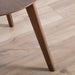 Close up view of the leg of a mid-century modern walnut finish round wood side table with splayed legs