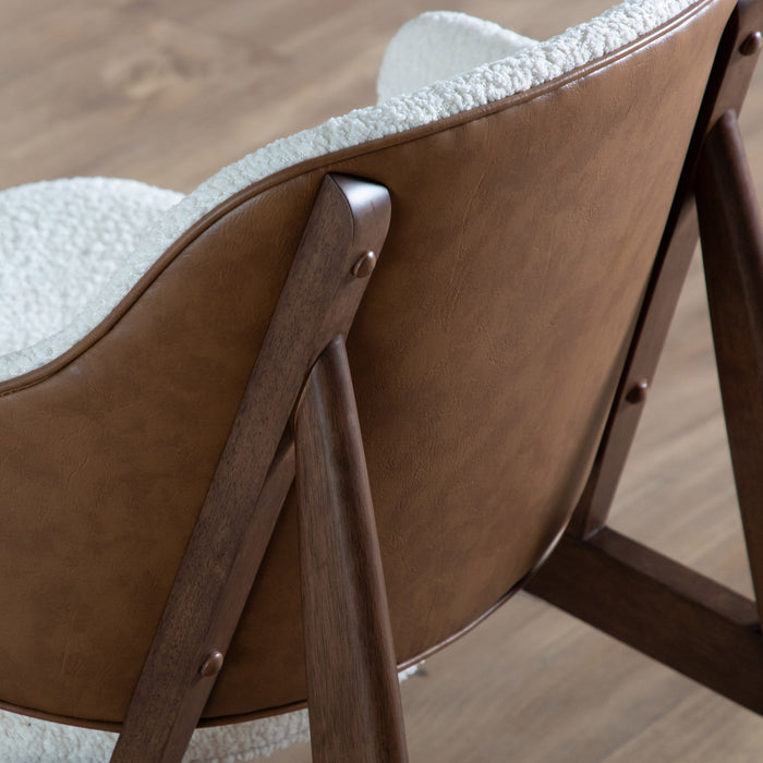 Left facing back view of a mid-century modern walnut and ivory boucle accent armchair in a room