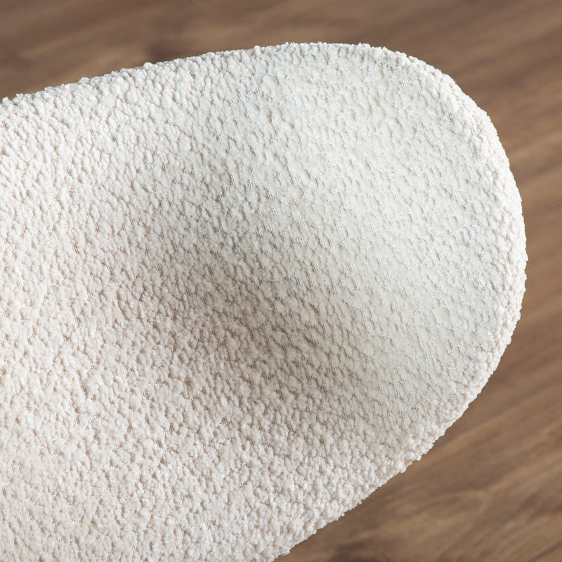 Right facing close up of the wingback of a mid-century modern walnut and ivory boucle wingback accent chair in a room