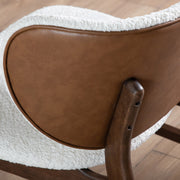 Left facing close up of the wingback of a mid-century modern walnut and ivory boucle wingback accent chair in a room