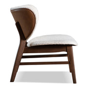 Front facing side view of a mid-century modern walnut and ivory boucle wingback accent chair on a white background