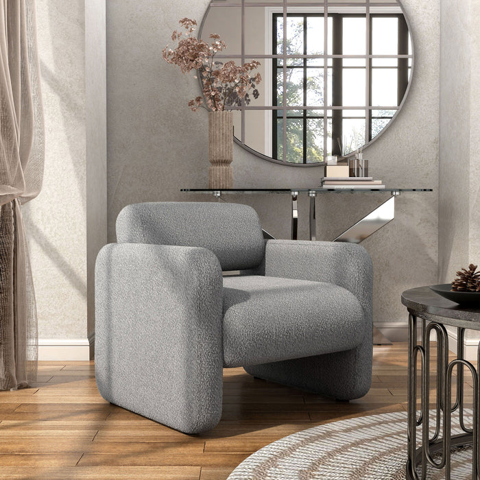 Right facing contemporary gray boucle upholstered accent armchair in a room with accessories