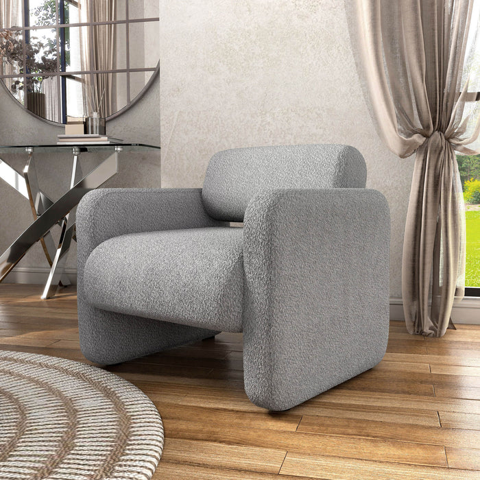 Left facing contemporary gray boucle upholstered accent armchair in a room with accessories