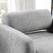 Right facing close up view of the backrest and seat on a contemporary gray boucle upholstered accent armchair in a room with accessories