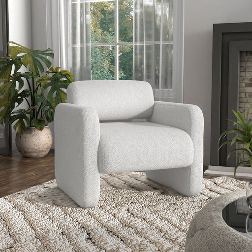 Right facing contemporary white boucle upholstered accent armchair in a room with accessories