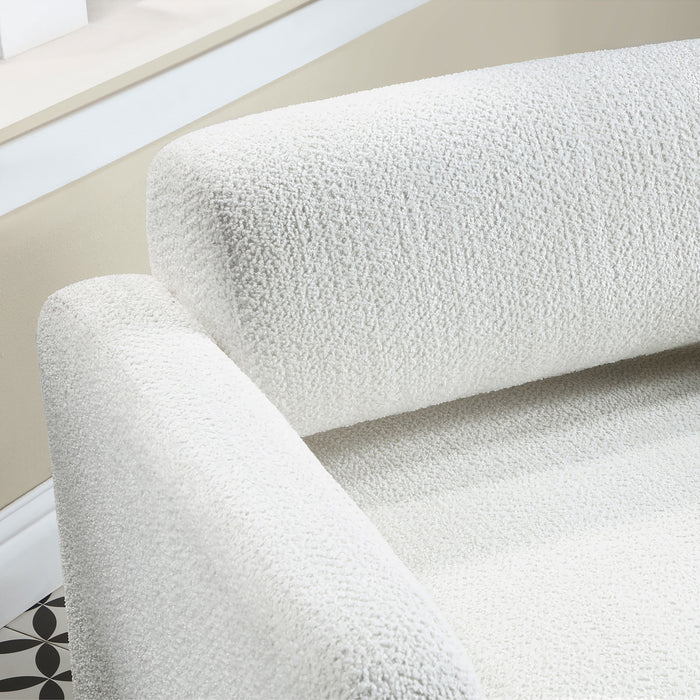 Right facing close up view of the backrest and arm of a contemporary white boucle upholstered accent armchair in a room