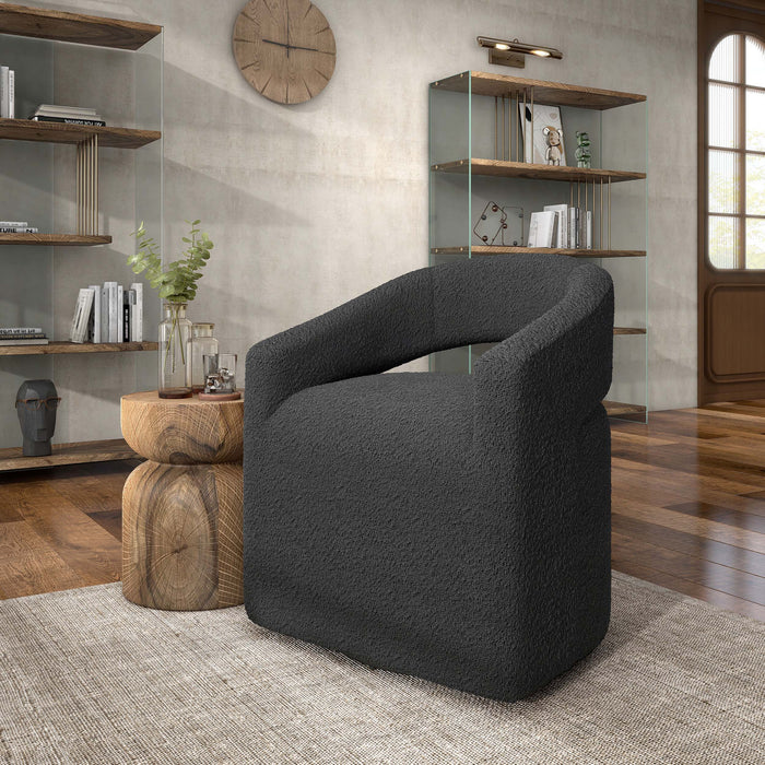 Left facing contemporary charcoal grey boucle 360-degree swivel accent chair in a room with accessories