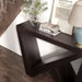 Left facing bird's eye close up view of a modern farmhouse espresso slant-design console table in a room with accessories