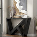 Left facing modern farmhouse black slant-design console table in a room with accessories