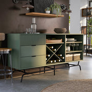 Right facing contemporary three-drawer sage green and black TV stand with a wine rack in a room with accessories