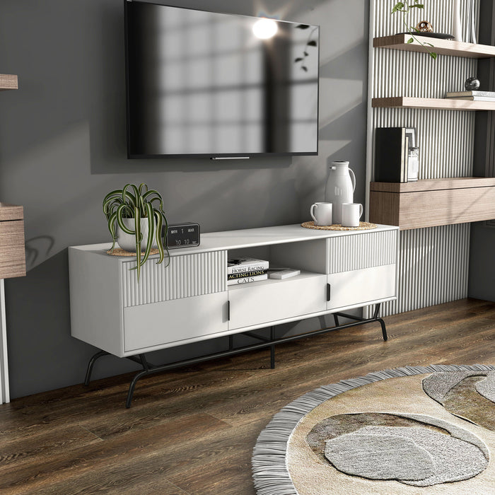 Right facing contemporary white and black three-drawer two-door TV stand with fluting in a room with accessories