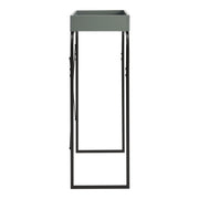 Front facing side view of a modern sage green and black tray style console table on a white background