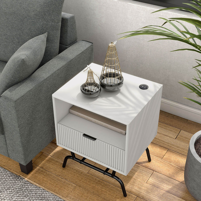 Left facing bird's eye view of a contemporary one-drawer wave-front pure white and black end table with USB ports in a room with accessories