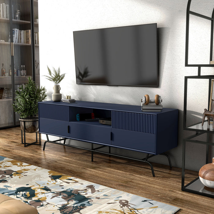 Left facing contemporary indigo blue and black three-drawer two-door TV stand with fluting in a room with accessories
