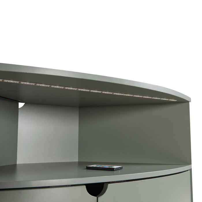 Right facing close up of a contemporary sage green two-door corner cabinet with LED lighting on a white background