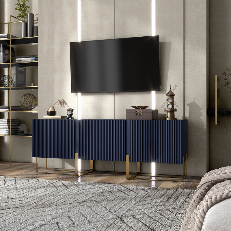Left facing contemporary indigo blue and vintage gold fluted three-door TV stand in a room with accessories