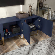 Right facing bird's eye close up view of a contemporary indigo blue and vintage gold fluted three-door TV stand with doors open in a room with accessories