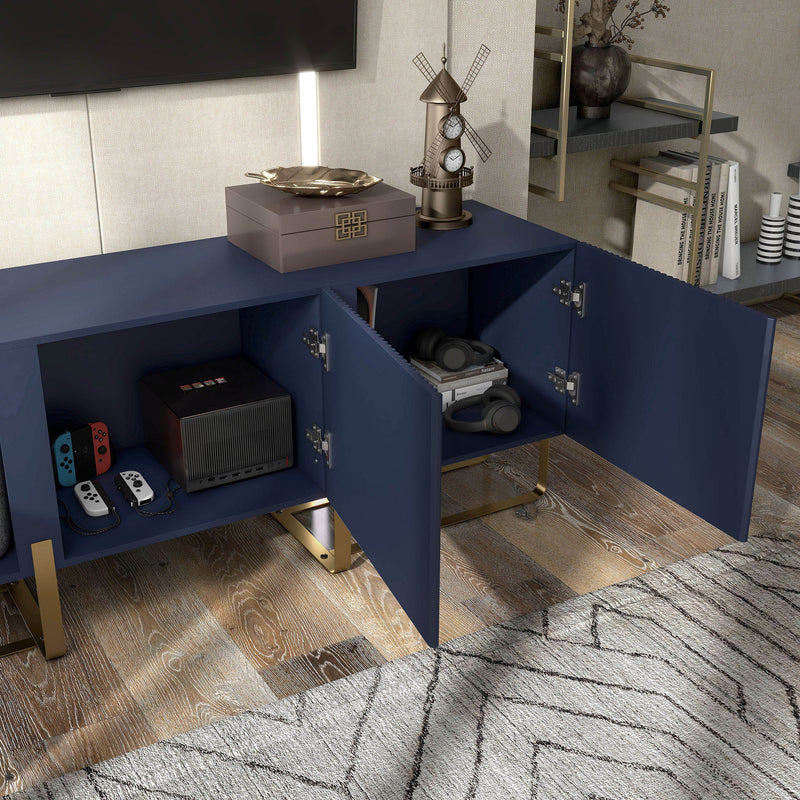 Right facing bird's eye close up view of a contemporary indigo blue and vintage gold fluted three-door TV stand with doors open in a room with accessories