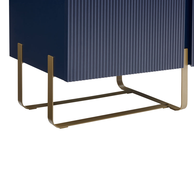 Right facing close up view of the door and leg of a contemporary indigo blue and vintage gold fluted three-door TV stand on a white background
