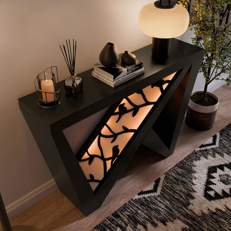 Right facing bird's eye view of a contemporary black W-shaped console table with LED accent lighting and a bird pattern in a room with accessories