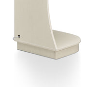 Right facing close up view of the base shelf and back of a contemporary cream weave five-shelf curved corner bookcase with LED lighting on a white background