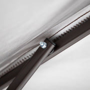 Close up of the support structure of a transitional burgundy outdoor pop-up canopy with one shade wall