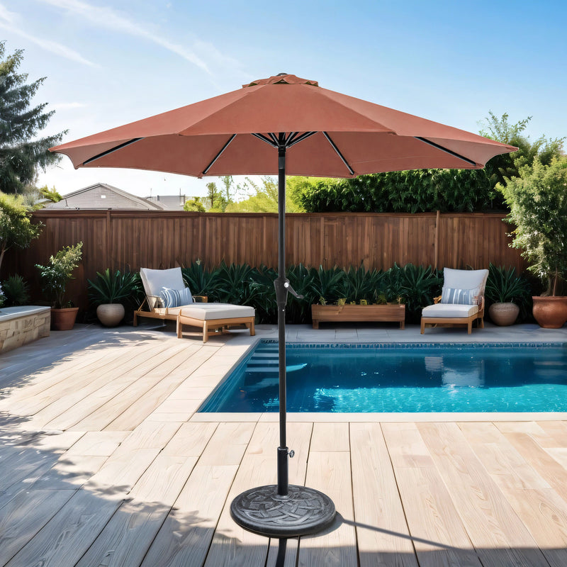 Front facing contemporary red outdoor auto tilt umbrella with a carrying case on a patio with accessories