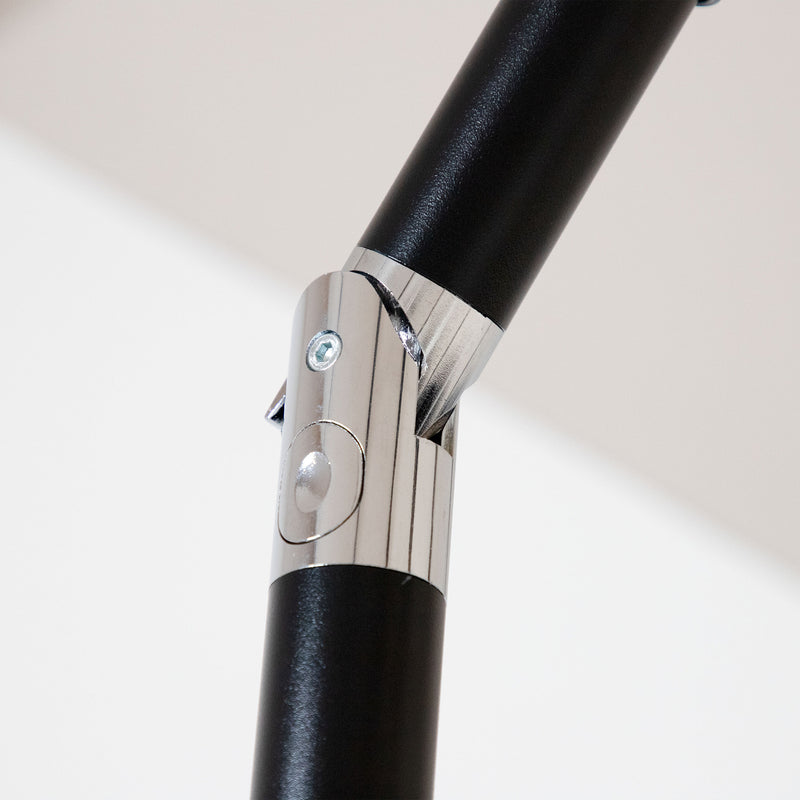 Close up of the tilt mechanism of a contemporary red outdoor auto tilt umbrella with a carrying case on white background