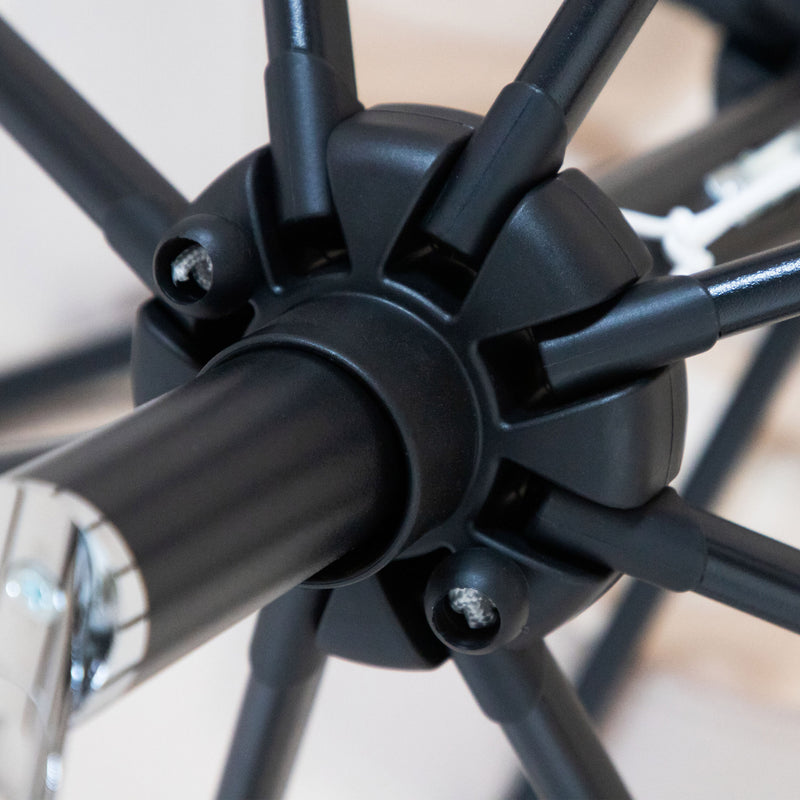 Close up of the sliding pop-up mechanism of a contemporary red outdoor auto tilt umbrella with a carrying case on white background
