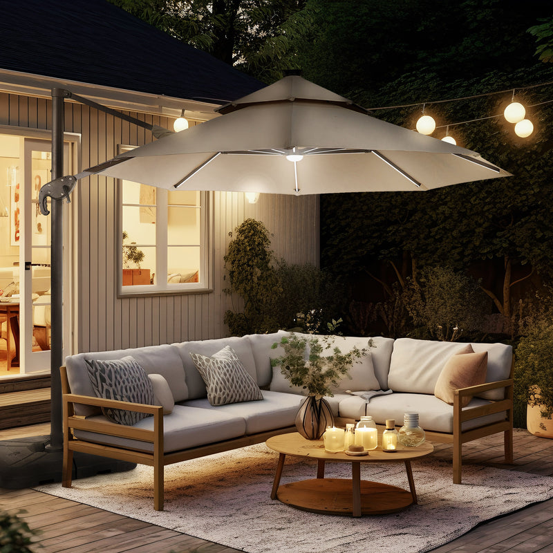 Right facing contemporary cantilever umbrella in tan fabric with solar LED lighting and carrying case at night on a patio with accessories