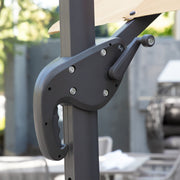 Right facing close up of the crank mechanism on a contemporary umbrella in tan fabric with solar LED lighting (base not included) on a patio