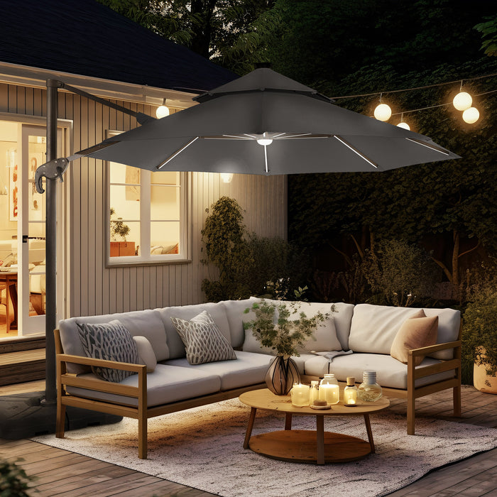 Right facing contemporary cantilever umbrella in grey fabric with solar LED lighting and carrying case at night on a patio with accessories