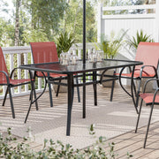 Right facing transitional black and textured glass patio outdoor dining table on a patio with accessories