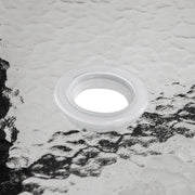 Close up of the tabletop umbrella opening of a transitional black and textured glass patio outdoor dining table on a white background