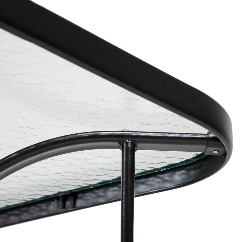 Close up of the rounded corner and support structure of a transitional black and textured glass patio outdoor dining table on a white background