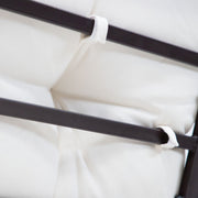 Close up of the chair cushion loops of a four-piece transitional beige outdoor patio seating set with a table, two chairs, and a loveseat on a white background