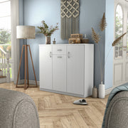 Left facing contemporary white three-door one-drawer shoe cabinet in a room with accessories