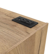 Left facing close up view of the charging port on a rustic light oak one-drawer nightstand with an open shelf and a charging port in the tabletop on a white background