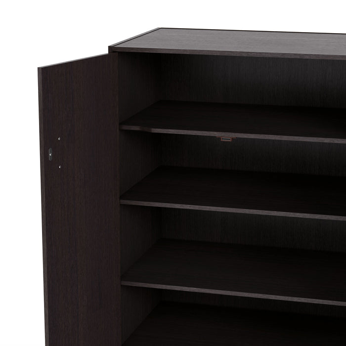 Left facing close up view of the open door and interior shelving of a contemporary espresso three-door one shelf shoe cabinet on a white background