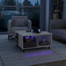 Left facing contemporary white and brown storage coffee table with a glass inset and LED lighting in a room with accessories