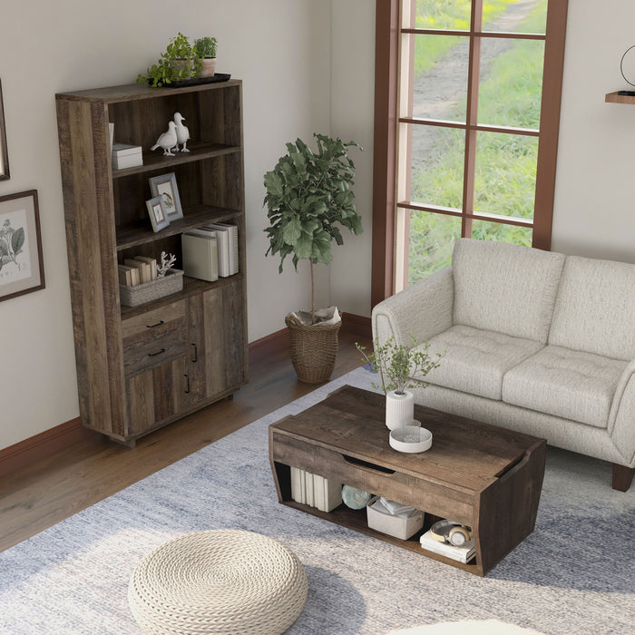 Top view of a reclaimed oak storage coffee table and bookcase set in a modern farmhouse style living room. The chest-like coffee table, in front of the beige loveseat, features an open shelf on the base frame displaying books and a basket. Three spacious shelves on the bookcase display more books and decor. An indoor tree cushions the corner between the bookcase and loveseat, while a round rattan floor ottoman sits in the foreground of the coffee table.