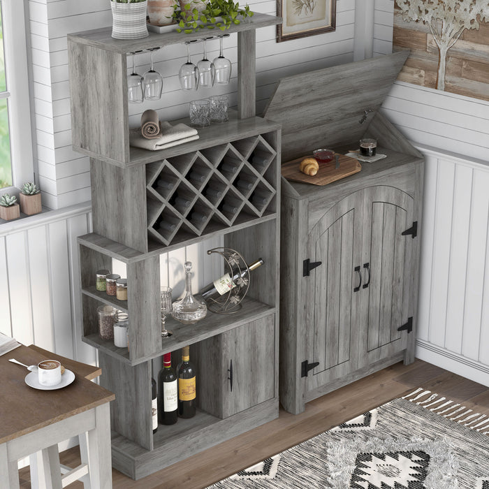 Top view of a vintage grey oak wine bar against a shiplap wall. Wine glasses hang on the stemware racks and 11 wine bottles nestle in the trellis wine rack. The roof of the bar is lifted to offer a shelf for a cutting board with a croissant and jam. A glass of coffee also rests on the counter.