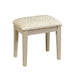 Right-angled white stool against a white background. The fabric upholstered seat sits on tapered legs.
