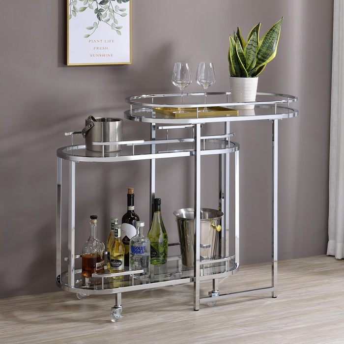 Right-angled chrome bar cart in a chic home. Wine glasses perch on the stationary shelf, an ice bucket awaits on the top shelf of the mobile cart, and select bottles adorn the bottom shelf.