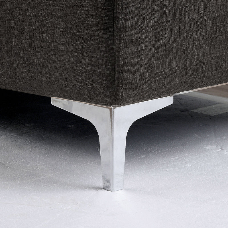 Left angled close up contemporary gray storage chaise with detail of sleek chrome legs on a white background