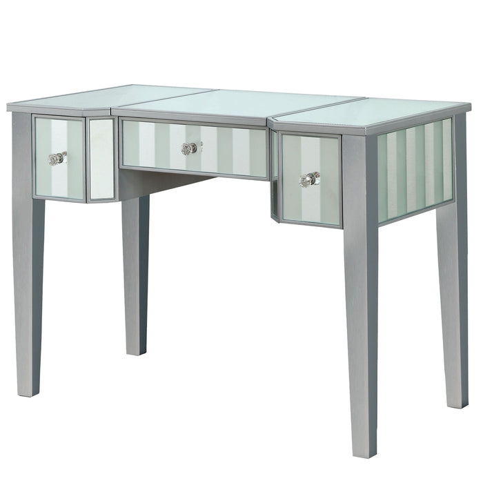 Left-angled silver vanity table against a white background. This vanity table features a mirrored tabletop and stripe frosted mirrored drawers with acrylic knobs.