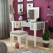 Left-angled white vanity set in a bedroom. Pink flowers, a camera, and a notebook adorn the vanity table as the white set mingles with the magenta wall it sits against.